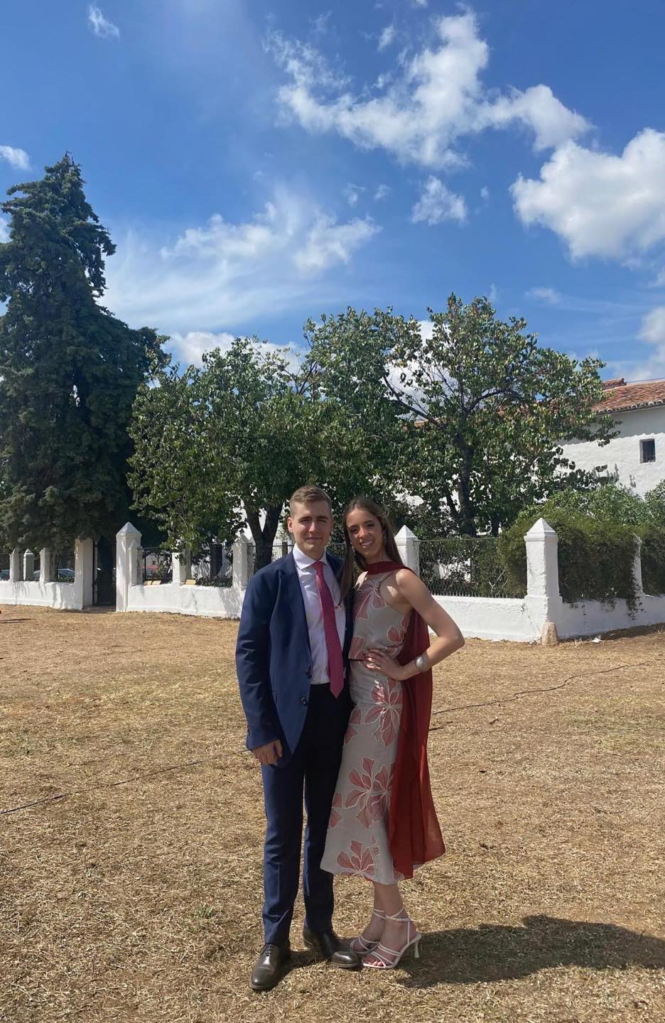 Juan y Elena vestidos de boda, al aire libre, en un día de sol.