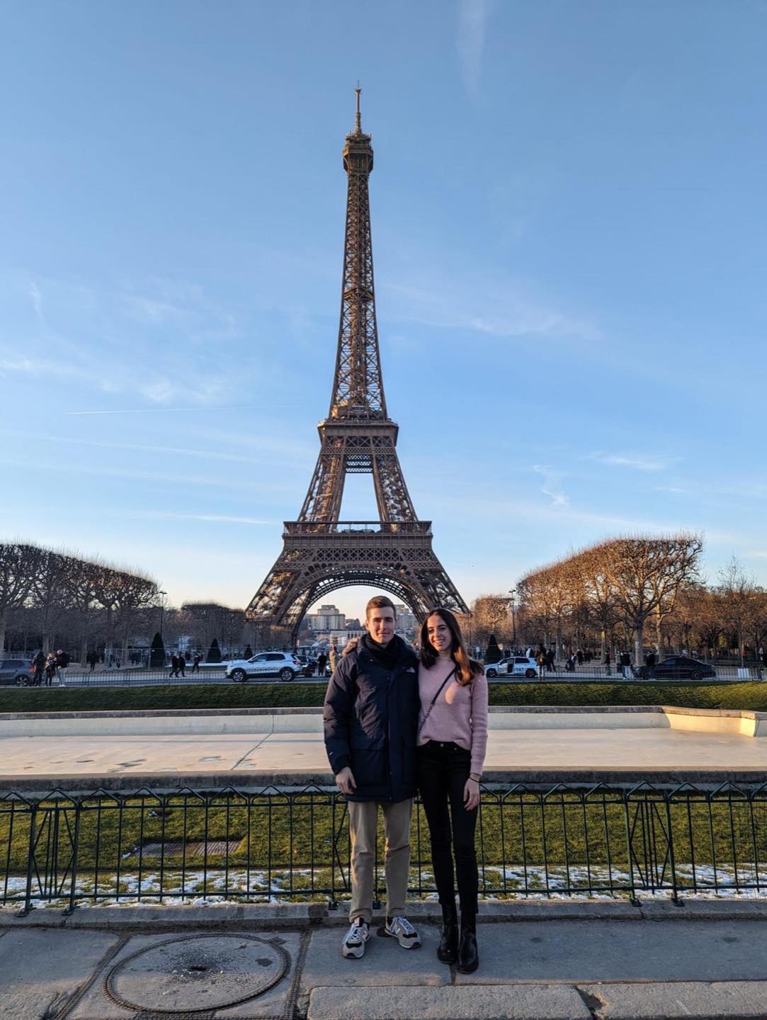 Los dos delante de la Torre Eiffel, abrigados, en invierno.